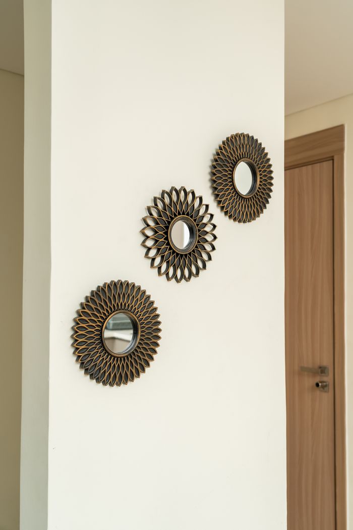 Stylish sunburst mirrors on a white wall add a modern touch to interior decor.